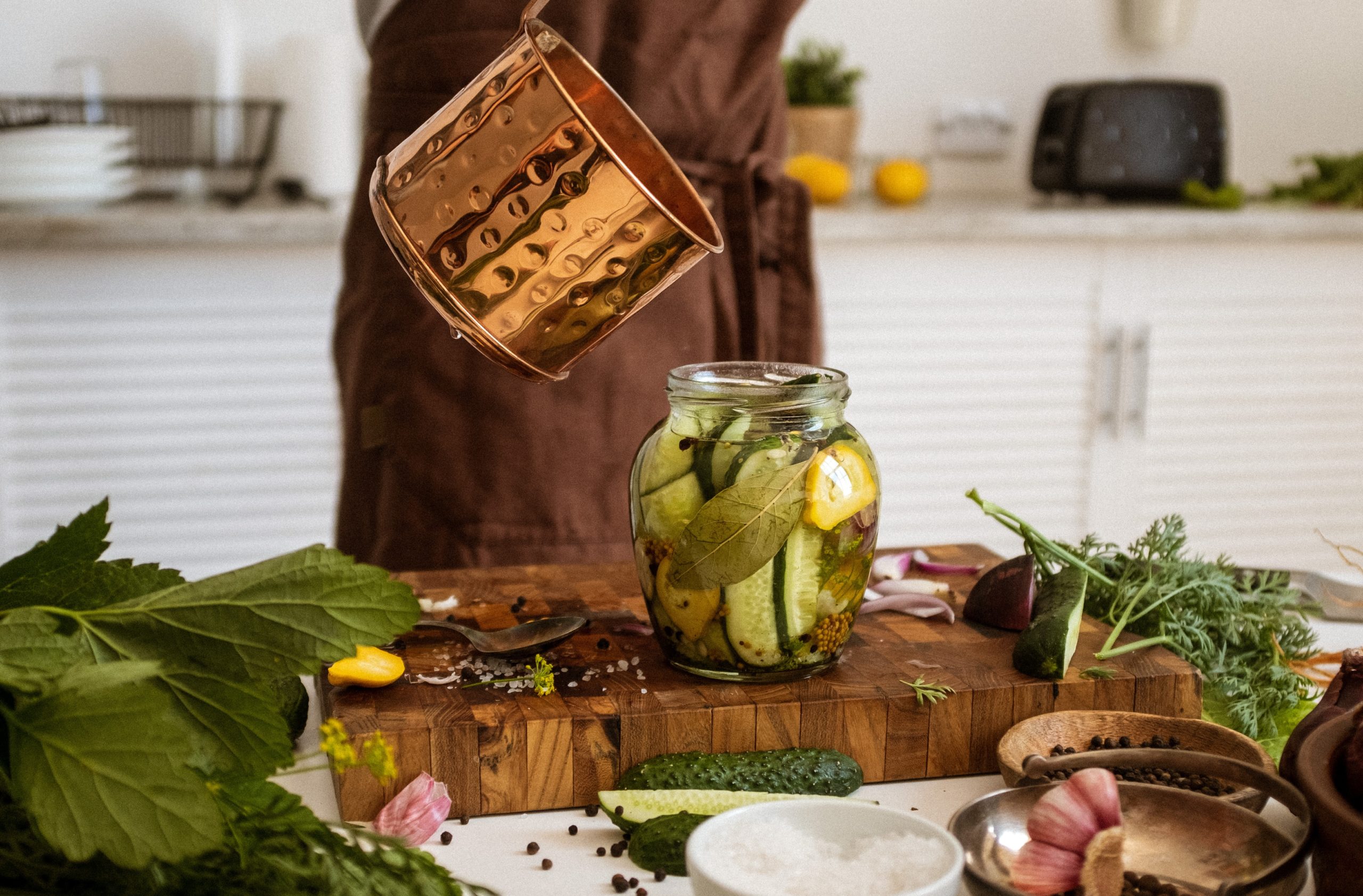 Préparation de pickles de cornichons dans un bocal en cuisine, lutte contre gaspillage alimentaire